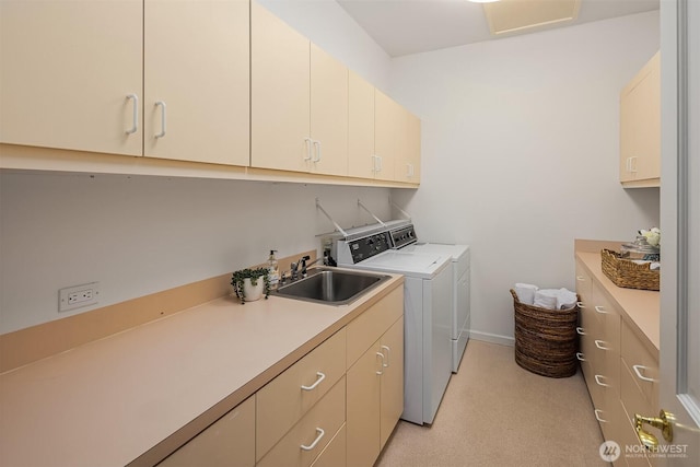 laundry room featuring a sink, baseboards, cabinet space, and washing machine and dryer