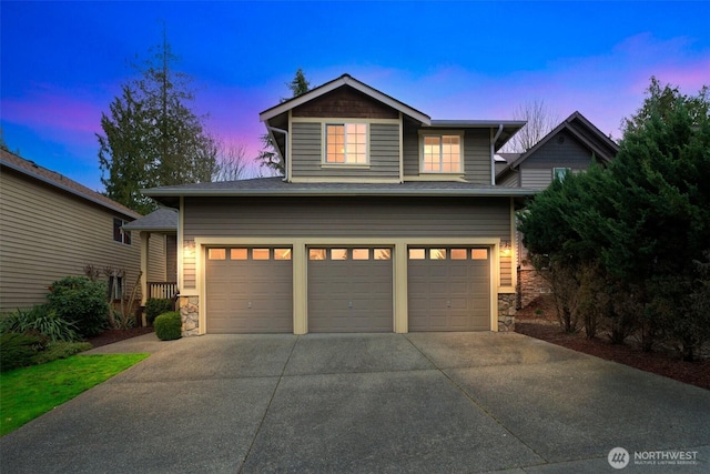 craftsman-style house with a garage, stone siding, and driveway