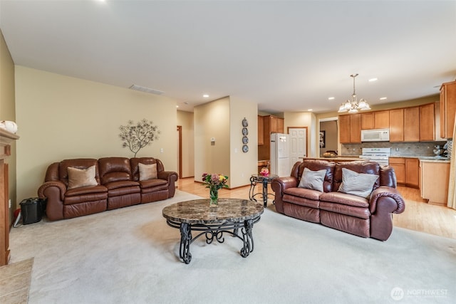 living room with light carpet, visible vents, recessed lighting, and an inviting chandelier