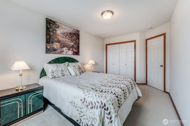 carpeted bedroom featuring a closet and baseboards