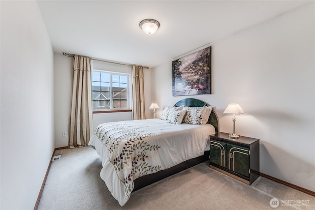 bedroom with baseboards and light carpet