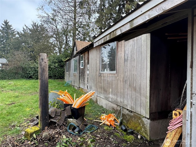 view of property exterior with a lawn and roof with shingles