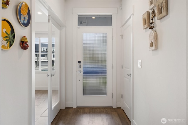 doorway with wood finished floors and baseboards