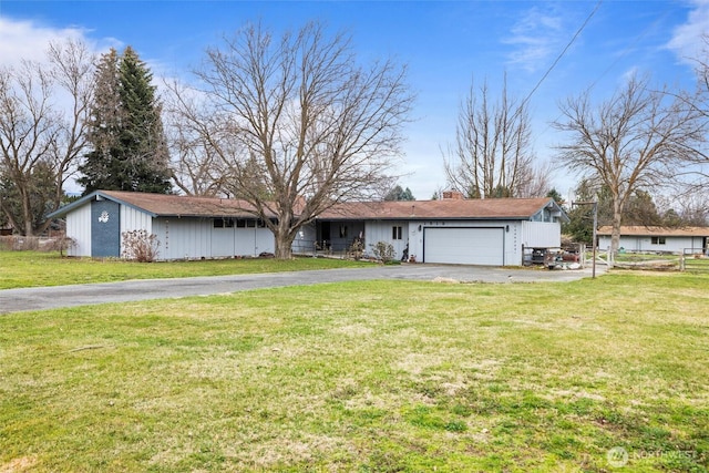 ranch-style house featuring aphalt driveway, an attached garage, a front lawn, and fence