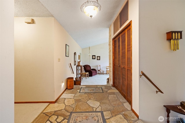 hall with baseboards, carpet floors, an upstairs landing, and vaulted ceiling