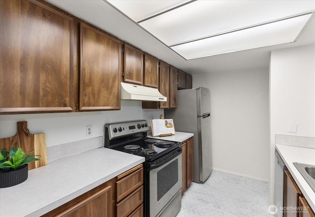 kitchen featuring baseboards, under cabinet range hood, light countertops, stainless steel appliances, and a sink