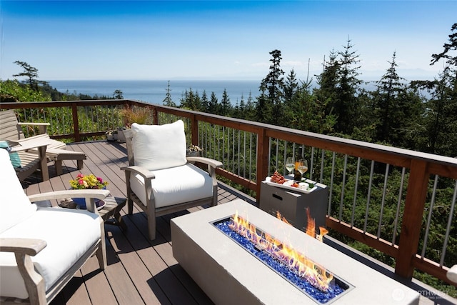 wooden deck featuring a fire pit and a water view