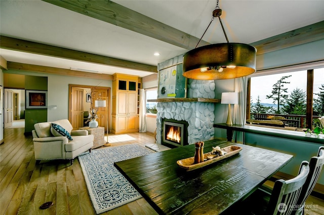 living room with hardwood / wood-style flooring, beam ceiling, and a fireplace