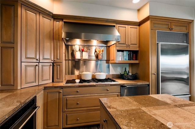 kitchen with wall chimney range hood and stainless steel appliances