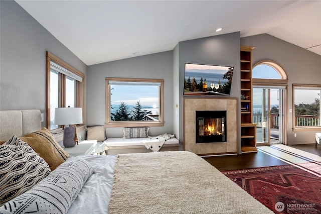 bedroom with lofted ceiling, access to exterior, dark wood-type flooring, and a fireplace