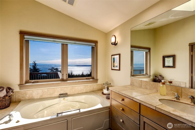 full bath featuring vaulted ceiling, vanity, a whirlpool tub, and visible vents