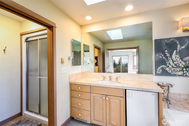 full bath featuring recessed lighting, a shower stall, vanity, a skylight, and baseboards