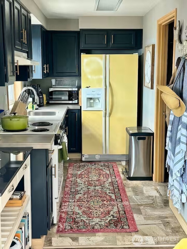 kitchen with light countertops, a toaster, white fridge with ice dispenser, and electric range
