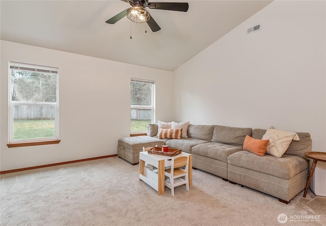 living area with vaulted ceiling, visible vents, light carpet, and a healthy amount of sunlight