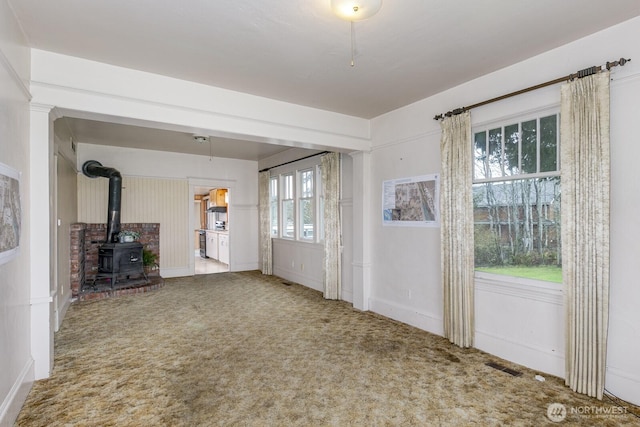 249 Cascade Ave, Langley, WA 98260 - interior space with visible vents, a wood stove, and carpet