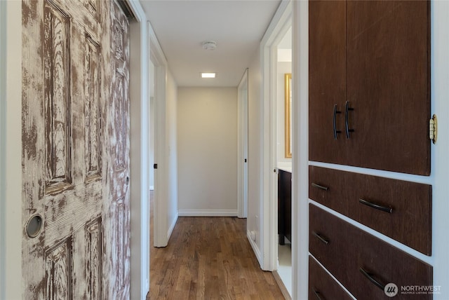 hallway with baseboards and wood finished floors