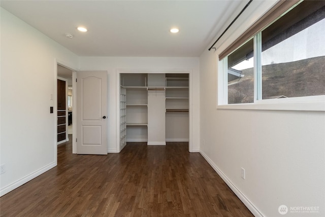 unfurnished bedroom with a closet, recessed lighting, baseboards, and wood finished floors