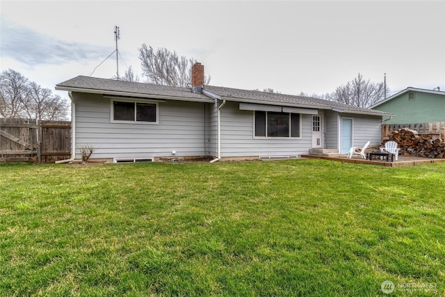 back of property featuring a yard, a chimney, and fence