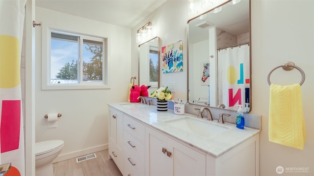 full bath featuring a sink, visible vents, and wood finished floors