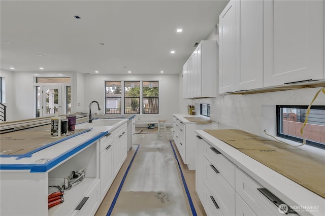 kitchen featuring decorative backsplash, white cabinets, and recessed lighting