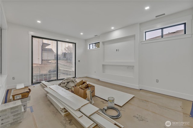 unfurnished living room featuring visible vents, recessed lighting, and baseboards