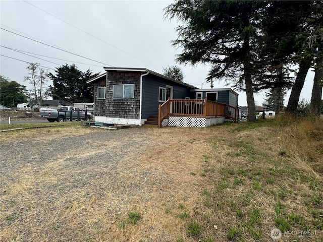 exterior space featuring a wooden deck and driveway