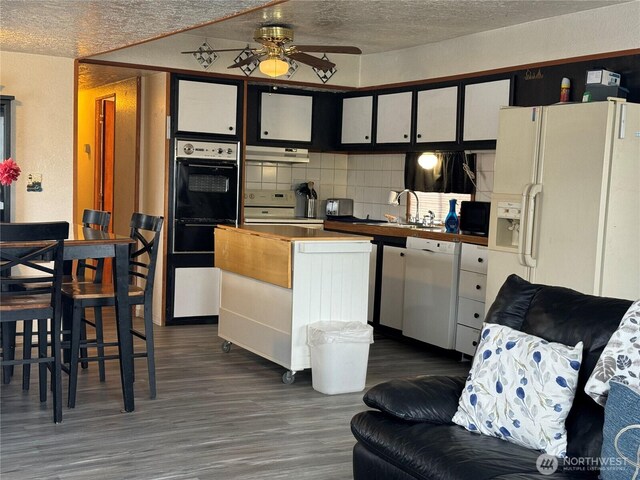 kitchen with electric range, oven, dark wood-type flooring, under cabinet range hood, and dishwasher