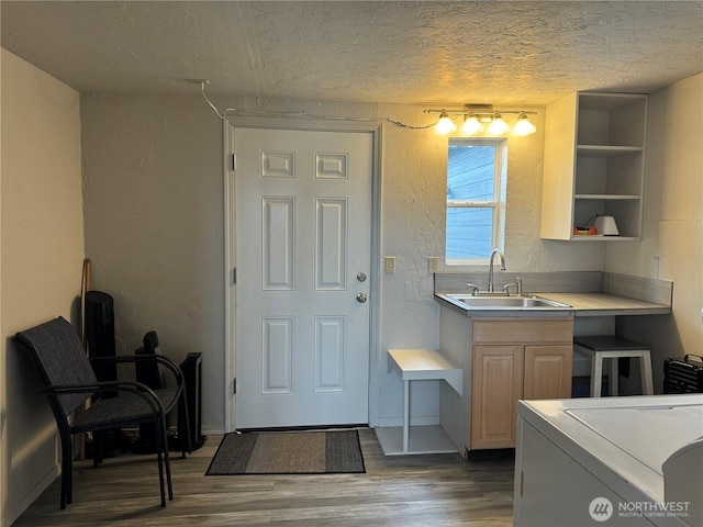 kitchen with a sink, open shelves, a textured ceiling, wood finished floors, and light countertops