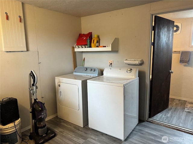 laundry room with baseboards, laundry area, wood finished floors, independent washer and dryer, and a textured ceiling