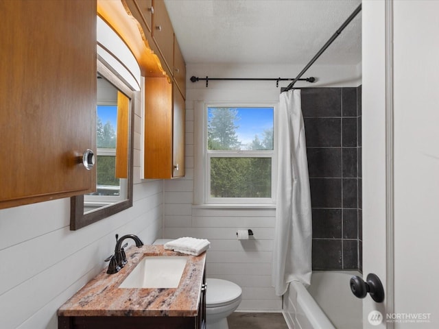 full bathroom featuring shower / bath combo with shower curtain, toilet, a textured ceiling, wood walls, and vanity