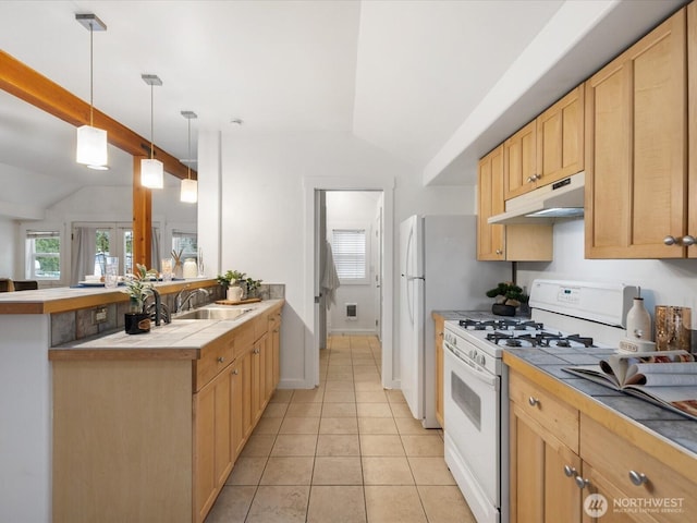 kitchen featuring tile countertops, a peninsula, white gas stove, light tile patterned flooring, and under cabinet range hood