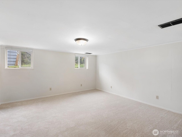 unfurnished room featuring visible vents, light colored carpet, and baseboards