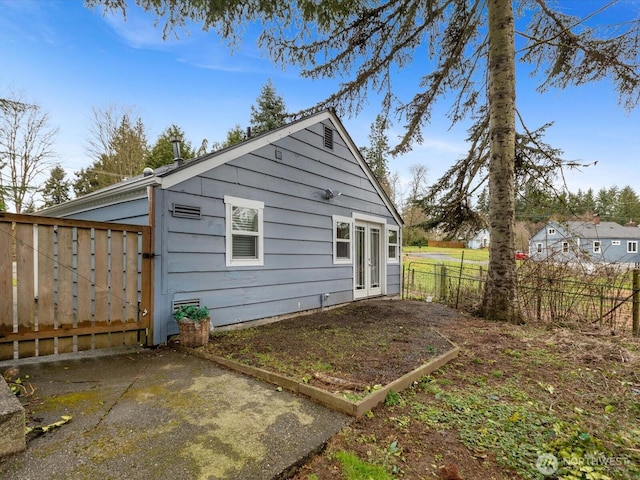 back of property with french doors and fence