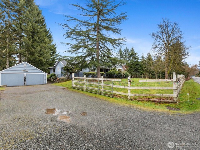 exterior space featuring a garage, an outdoor structure, and fence