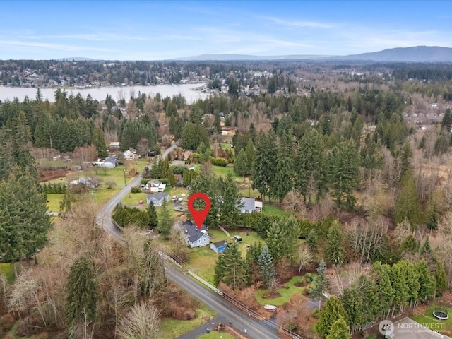 bird's eye view featuring a wooded view and a water view