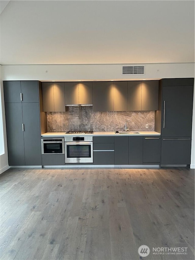 kitchen featuring a sink, gray cabinetry, stainless steel appliances, and modern cabinets