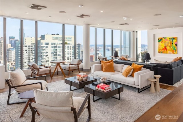 living room with a view of city, wood finished floors, and visible vents