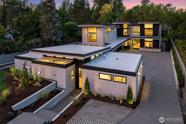 modern home featuring stucco siding and fence