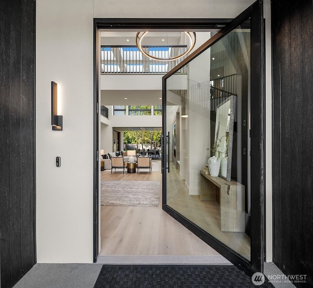 foyer entrance featuring a towering ceiling and wood finished floors