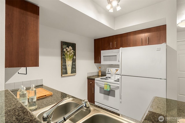 kitchen featuring dark countertops, white appliances, ceiling fan, and a sink