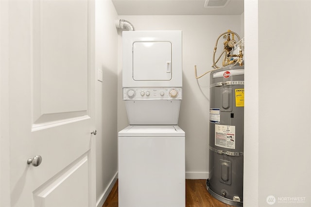 clothes washing area with baseboards, secured water heater, laundry area, dark wood-style flooring, and stacked washer and dryer