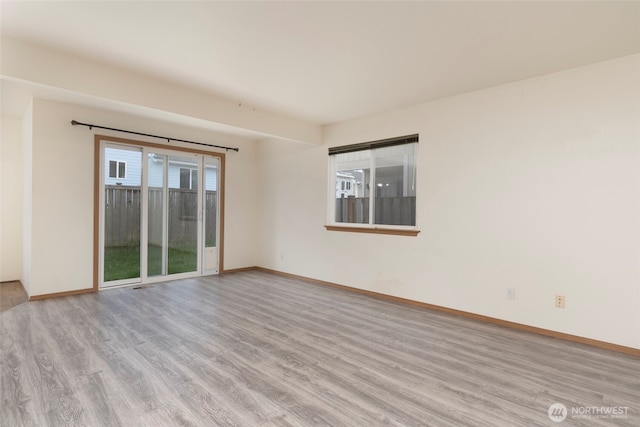 spare room featuring baseboards and wood finished floors