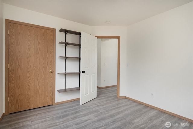 unfurnished bedroom with wood finished floors and baseboards