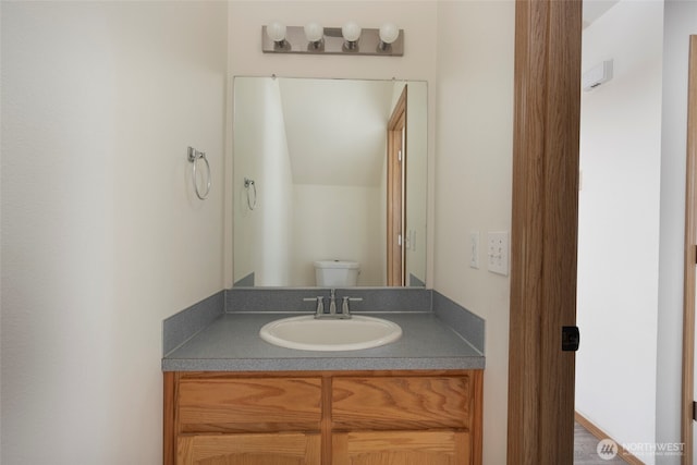 half bathroom with vanity and toilet