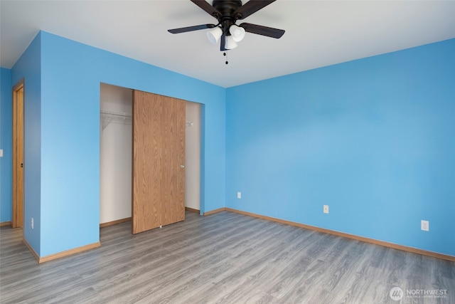 unfurnished bedroom with ceiling fan, a closet, baseboards, and wood finished floors