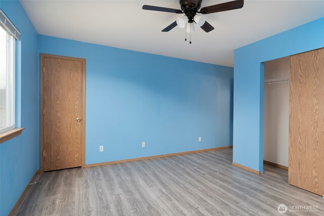 unfurnished bedroom with ceiling fan, a closet, baseboards, and wood finished floors