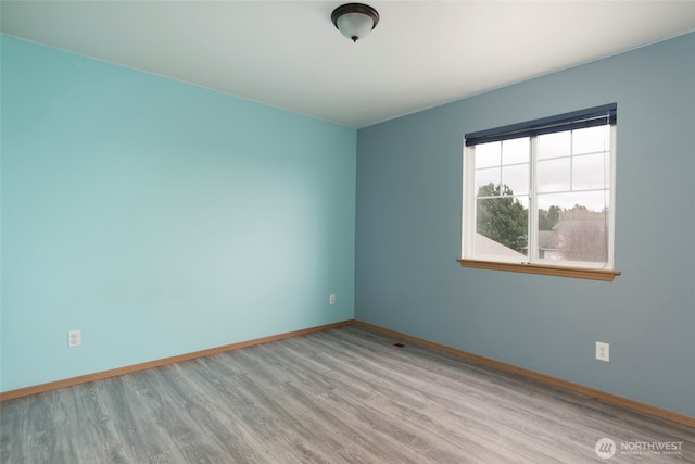 unfurnished room with wood finished floors and baseboards