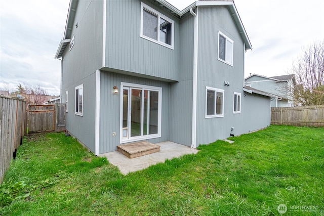 back of property with a lawn and a fenced backyard