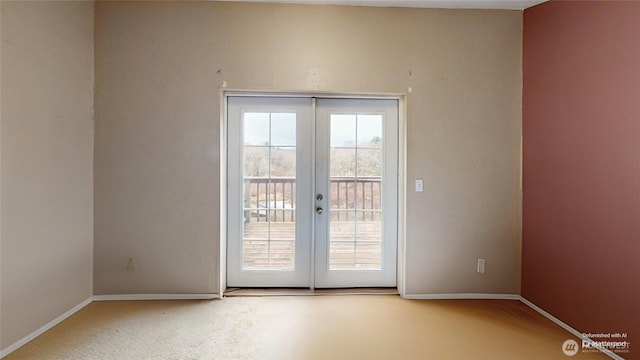 unfurnished room featuring french doors and baseboards