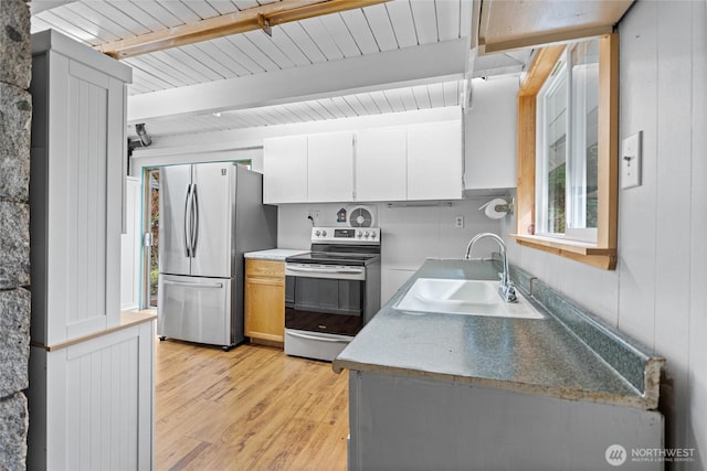 kitchen featuring beamed ceiling, light wood-style flooring, a sink, white cabinetry, and appliances with stainless steel finishes